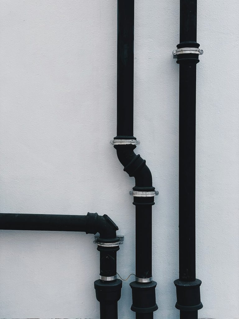 black-metal-pipe-on-white-wall-ctiahomdmqm
