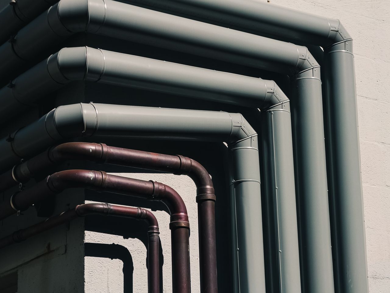 Mastering the First Impression: Your intriguing post title goes here Close-up of industrial pipes forming a pattern on a buildings exterior wall, shot outdoors.